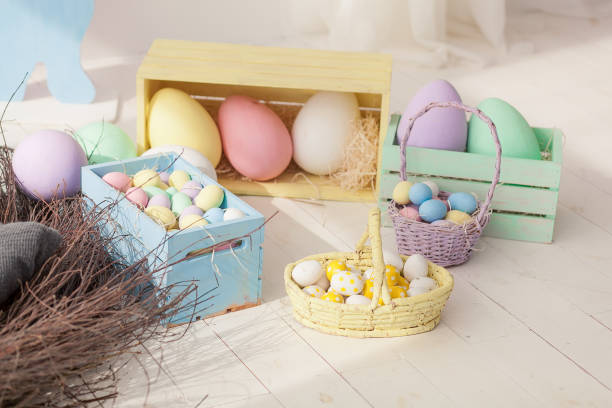 istock Multicolored easter eggs and in basket and wooden boxes on floor 924437308