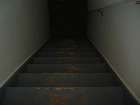 Spooky old wooden staircase leading to a dark scary landing