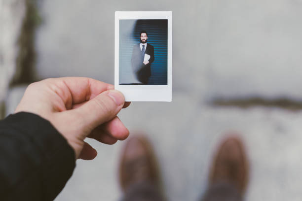 бизнесмен показывает мгновенный портрет - кисть руки фотографии стоковые фото и изображения