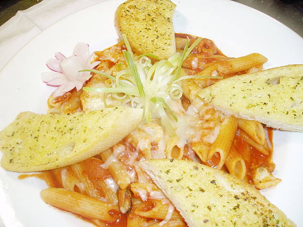 Penne Pasta in Tomato Sauce with Garlic Bread stock photo