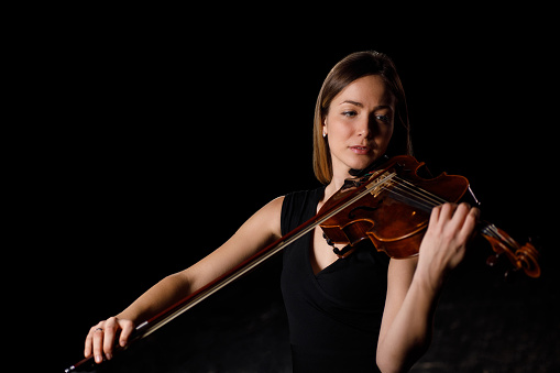 violinist's poise and intense gaze reflect the meticulous skill and passion that string performance demands