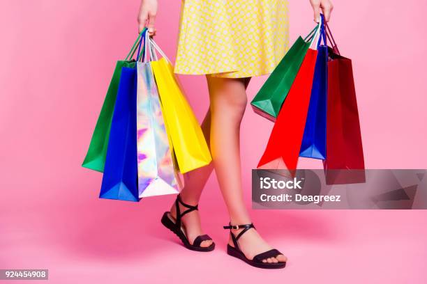 Cropped Portrait Of Womans Slim Sexy Legs Going From Shopping Having A Lot Of Colorful Bags In Hands Isolated On Pink Background Day Of Big Sales Stock Photo - Download Image Now