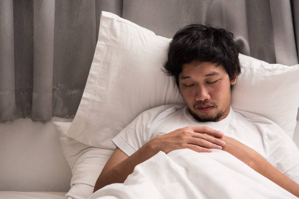 istock Asian man is sleeping on the bed in bedroom leave his work on computer. 924455626