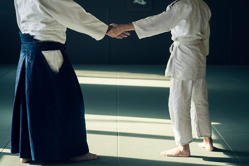 Teen boy with his sansei practicing in dojo