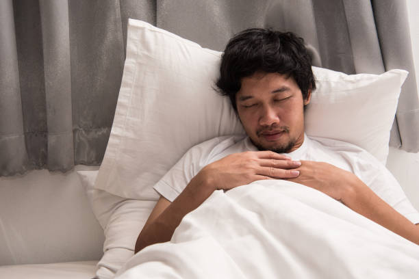 istock Asian man is sleeping on the bed in bedroom leave his work on computer. 924455932