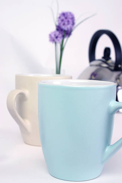 Tasses avec bouilloire sur blanc - Photo