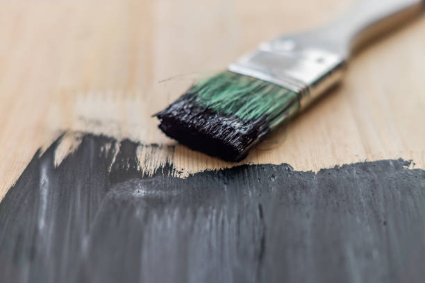 istock black paint on wooden background. selective focus 924459364