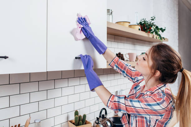 istock Woman in rubber gloves cleaning kitchen cabinet 924461722