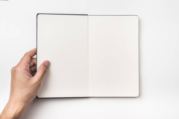 Top view of man's hand hold black hardcover notebook