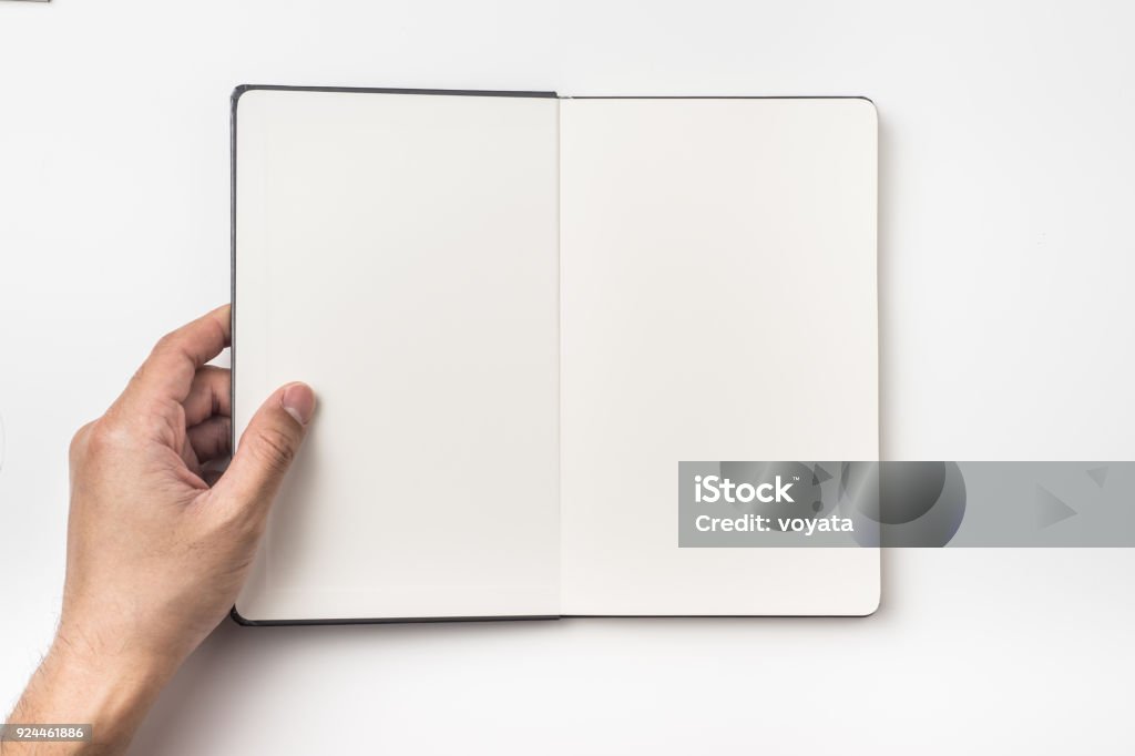 Top view of man's hand hold black hardcover notebook Business concept - Top view of man's hand hold black hardcover notebook isolated on background for mockup Hand Stock Photo