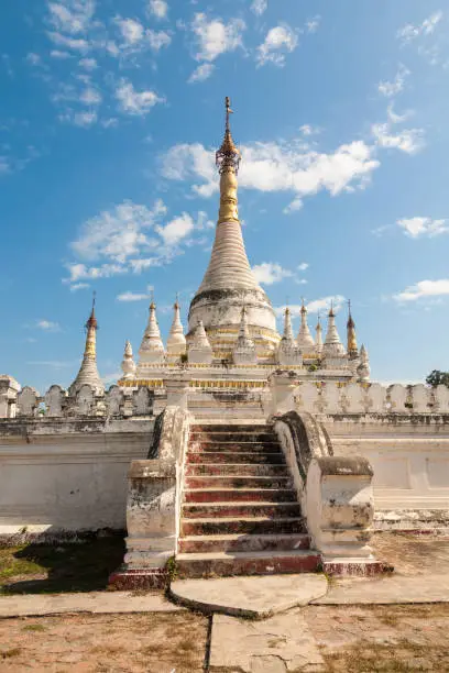 A white stupa with golden roof in the Maha Aung Mye Bon Zan monastery complex in the ancient site of Inwa or Ava near Mandalay in central Myanmar