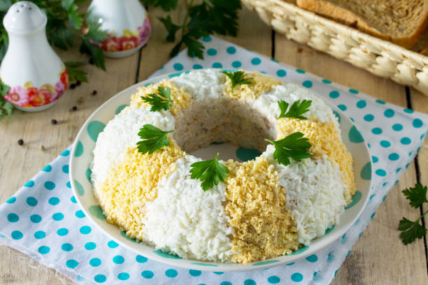 istock Easter recipe, festive appetizer. Salad with red fish, eggs, rice, pickled cucumbers - on the festive table. 924473286