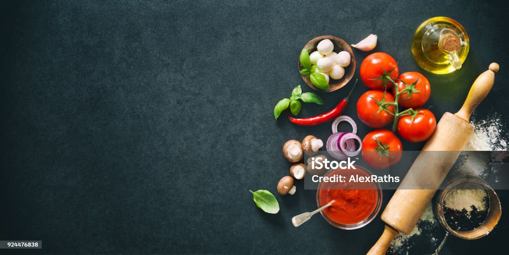 Delicious pizza with ingredients and spices Delicious pizza with ingredients and spices. Top view with copy space on wooden table Ingredient Stock Photo