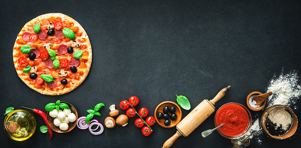 Delicious pizza with ingredients and spices. Top view with copy space on wooden table
