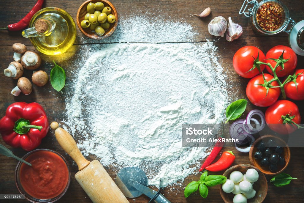 Ingredients and spices for making homemade pizza Ingredients and spices for making homemade pizza. Top view with copy space on wooden table Italian Food Stock Photo