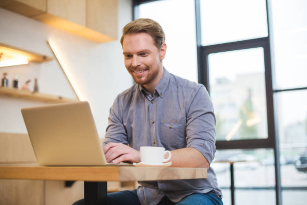 istock Cheerful nice man working on the laptop 924479386