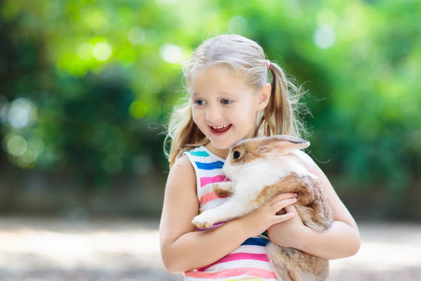 istock Child with rabbit. Easter bunny. Kids and pets. 924486488