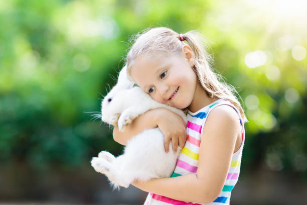 istock Child with rabbit. Easter bunny. Kids and pets. 924489952