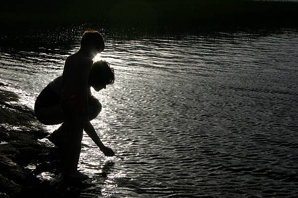 Boy in the water on a background of grass and trees