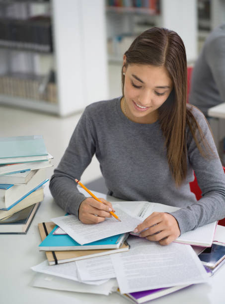 istock Latin american student reading books at the library and taking notes looking very concentrated 924504852