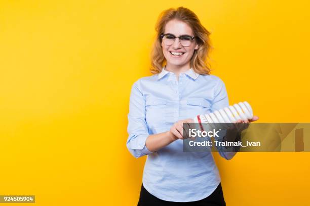 Attractive Woman With Energy Saving Bulb Stock Photo - Download Image Now - Adult, Adults Only, Blond Hair