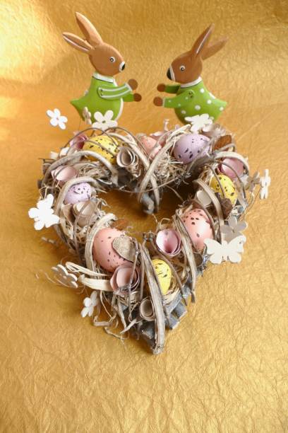 istock Easter egg wreath in heart shape on golden background 924508382