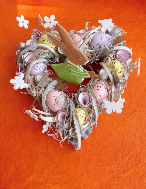 istock Easter egg wreath in heart shape on orange background 924508626