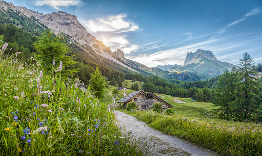 Alpine scenery in the Dolomites with mountain chalets at sunset in summer