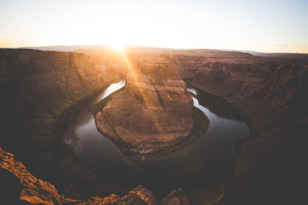 Classic wide-angle view of famous Horseshoe Bend, a horseshoe-shaped meander of the Colorado River located near the town of Page, in beautiful golden evening light at sunset in summer, Arizona, USA
