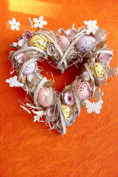 istock Easter egg wreath in heart shape on orange background 924508968