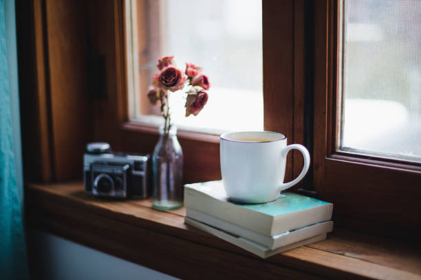 istock A cup of tea on books with dried roses on a window sill 924509082