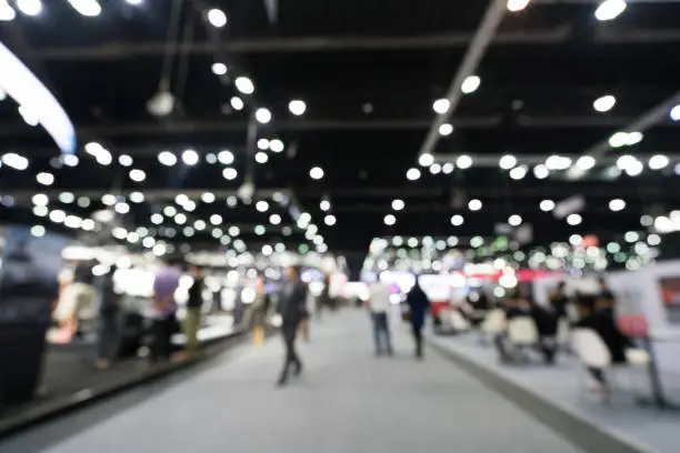 Photo of Blurred, defocused background of public exhibition hall. Business tradeshow or stock market, organization or company event, commercial trading fair, or shopping mall marketing advertisement concept