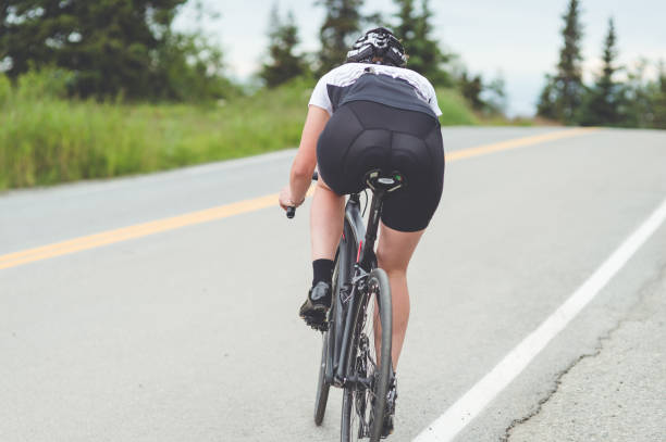 istock Female cyclist rides along a rural highway 924512710