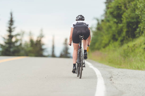 istock Female cyclist rides along a rural highway 924512712