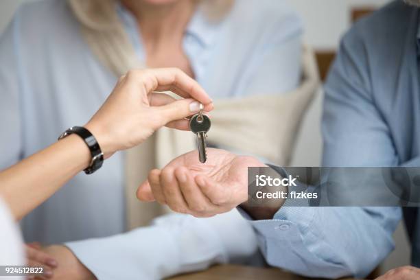 Couple Of Homeowners Getting Key To New House From Real Estate Agent Stock Photo - Download Image Now