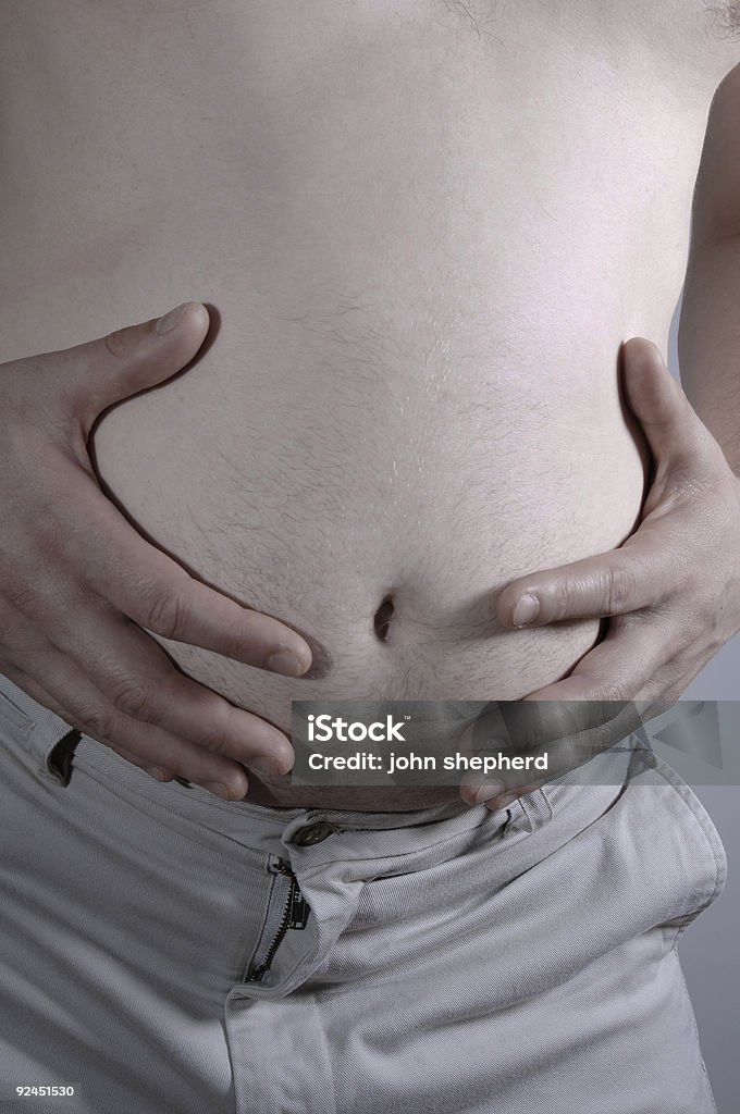 man holding overweight stomach Adult Stock Photo