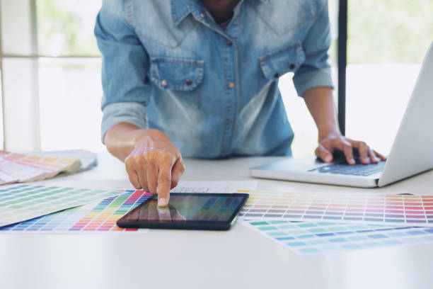 istock Color samples, colour chart, swatch sample, Graphic designer being selecting Color table and graphics tablet, pen at workplace with work example on wooden desk 924517444