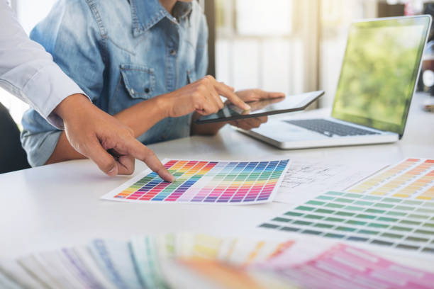 istock Young colleagues designers working together on a creative project and color samples for selection, Color swatch samples, Brainstorming Planning Partnership, creative graphic design working desktop 924517486