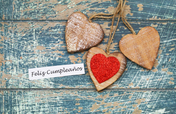 istock Feliz Cumpleanos (which means Happy Birthday in Spanish) with three wooden hearts 924517694