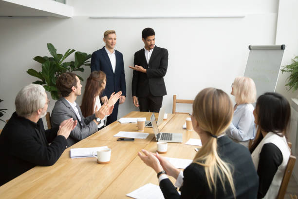 African boss introducing new hire employee to corporate team applauding African american boss or black hr executive ceo introducing new hire employee to corporate team applauding at group meeting, office workers clapping hands welcoming coworker with friendly ovation employee encouragement stock pictures, royalty-free photos & images