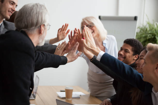 istock Multiracial young and senior businesspeople join hands giving high five 924520194