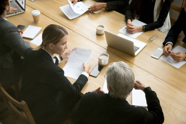 Negotiations concept, different businesspeople discussing deal details at group meeting Negotiations concept, different businesspeople discussing deal details at group meeting, young and senior partners team thinking talking consulting about contract sitting at conference office table mediation photos stock pictures, royalty-free photos & images