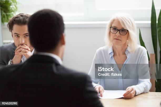 Grave Hr Senior Atento Escuchando El Candidato En Entrevista De Trabajo Foto de stock y más banco de imágenes de Serio