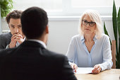 Serious attentive senior hr listening to candidate at job interview