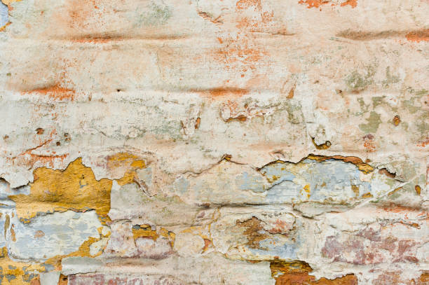 istock Close-up Textured background of multi-layer flaking paint on the wall. Mixing different colors of paints in the cleaved layers on the surface. Grunge texture with a deep pattern 924521410