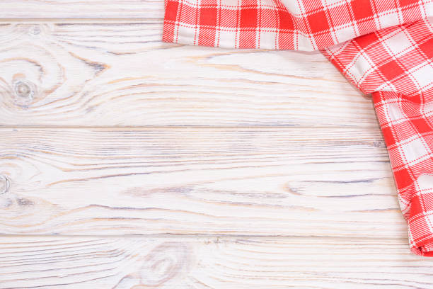 istock Red towel over wooden kitchen table. View from above with copy space 924524356