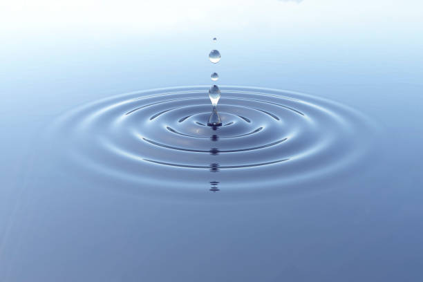 istock Water Droplet into still water with ripples in daylight 924533344