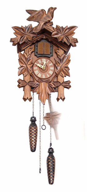 A vintage handmade wooden Cuckoo Clock on a white wall