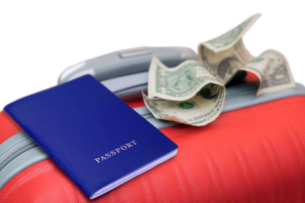 istock On the red suitcase is a blue passport and two crumpled dollar bills. 924537166