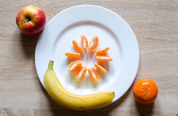 Plate of fruits on a table. Banana kivi and mandarine